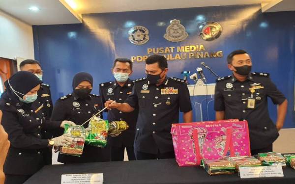 Mohd Shukhairy (dua, kanan) menunjukkan syabu yang dirampas daripada sindiket dadah dalam sidang akhbar di Ibu Pejabat Polis Kontijen Pulau Pinang, pada Isnin.