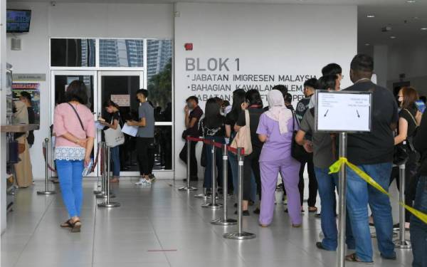 Orang ramai masih beratur menunggu giliran di hadapan bangunan Imigresen di Kompleks Kementerian Dalam Negeri di Setia Tropika, ketika tinjauan, pada Isnin. - Foto Bernama 