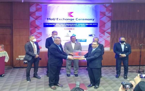 Muhammad Sanusi menyaksikan pertukaran MoU antara Pengarah Eksekutif Pusat Pembangunan Kemahiran Industri dan Pengurusan Kedah Darulaman (Kismec) Mohd Yusuri Yusof (kiri) dan rakan strategik pada Isnin.