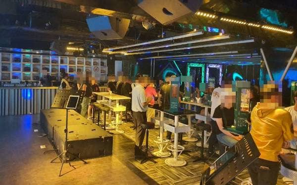Polis memeriksa pelanggan dan pekerja sebuah pusat karaoke dalam serbuan yang dilakukan pada Isnin.