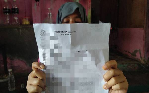 Lina menunjukkan laporan polis yang dibuat berhubung kejadian terbabit.