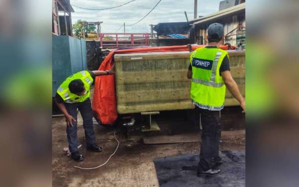 Pegawai KPDNHEP Alor Setar sedang memeriksa tangki tambahan atas lori di sebuah bengkel besi di Gurun, pada Ahad.