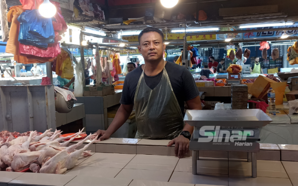 Azman menunjukkan ayam tua yang dijual di gerai selepas bekalan ayam daging yang diterima daripada pembekal terhad sejak sebulan lalu.