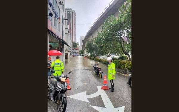 Anggota polis trafik sedang mengawal lalu lintas di lokasi banjir sekitar ibu kota pada Rabu.