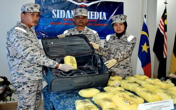 Iskandar (tengah) menunjukkan beg pakaian yang berisi 26 kilogram dadah dipercayai syabu bernilai RM1.04 juta yang dirampas dalam rondaan operasi khas pada sidang akhbar pada Rabu. - Foto Bernama