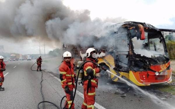 Pasukan bomba dan penyelamat melakukan kerja pemadaman api di lokasi kejadian kebakaran melibatkan sebuah bas persiaran di KM279.3 Lebuh Raya Utara-Selatan arah utara pada petang Rabu. - Foto JPBM