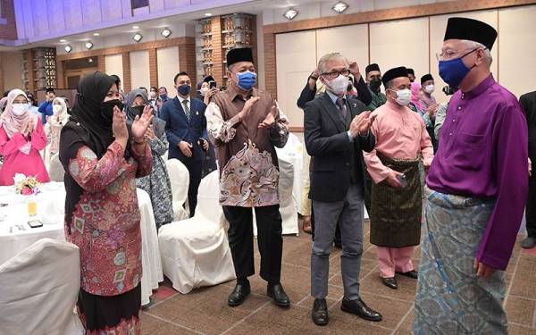 Ismail Sabri (kanan) beramah mesra dengan rakyat Malaysia yang menetap di Jepun pada sambutan hari raya bersama Keluarga Malaysia di Imperial Hotel Tokyo malam ini.- Foto Bernama