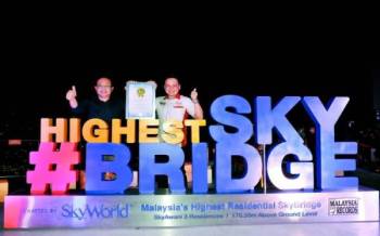 Chee Seng (kiri) dan Jwan Heah (kanan) bergambar bersama papan tanda SkyBridge Kediaman Tertinggi di Malaysia di aras 52.