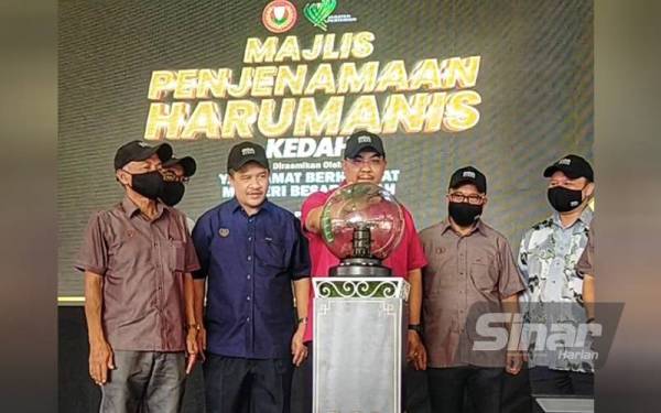 Muhammad Sanusi (tiga,kanan) menyempurnakan gimik pelancaran Harumanis D'Aman pada Majlis Perasmian Penjenamaan Harumanis Negeri Kedah di Pusat Teknologi Mempelam Sala Kanan di sini pada Khamis.