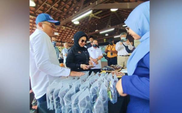Nordin (kiri) dan Haslina melihat projek ekonomi komuniti iGROW sempena lawatan kerjanya ke daerah kecil Kampung Gajah pada Jumaat.
