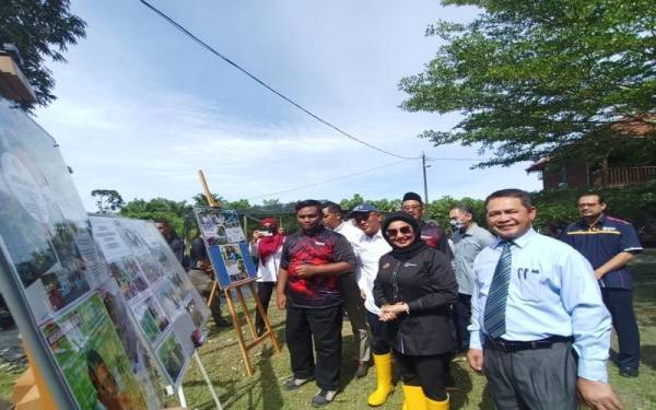 Haslina (dua dari kanan) ketika mendengar penerangan mengenai projek tanaman cili fertigasi belia di iGROW sempena lawatan kerjanya ke daerah kecil Kampung Gajah pada Jumaat.