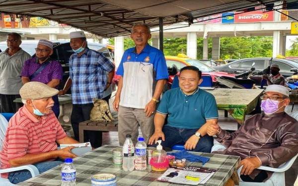 Wan Saiful ( dua, kanan) bertanya khabar pemandu teksi di Pekan Changlun selepas mengadakan pertemuan dengan mereka, pada Jumaat.