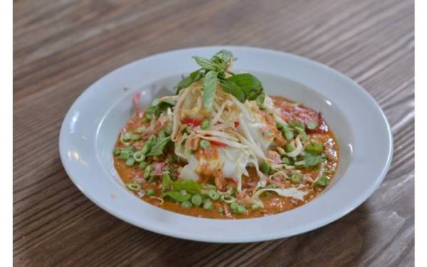 MENGGIURKAN. Laksam menjadi bertambah enak dengan tambahan ulam-ulaman seperti hirisan bunga kantan, kubis, kacang panjang, taugeh dan daun pudina.