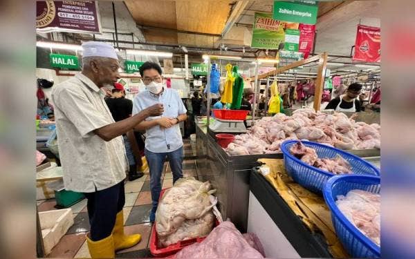Tze Tzin (dua dari kiri) ketika meninjau bekalan ayam di Pasar Awam Bayan Baru pada Sabtu.