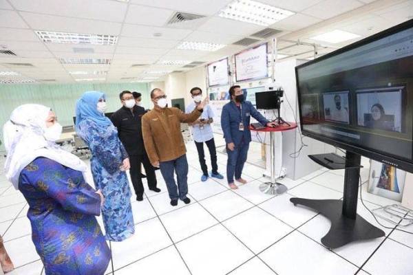 Rina (dua dari kiri) mendengar penerangan daripada Dr Amirudin berhubung teknologi dan pengoperasian Forensik Digital CyberSecurity Malaysia dalam lawatan di agensi tersebut di Menara CuberSecurity Malaysia pada Jumaat.