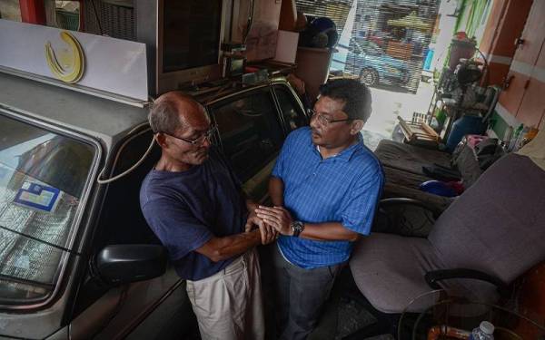 Syed Mohd Fazmi (kanan) ketika melawat veteran ATM, Mohd Redzuan yang tinggal di dalam kereta selama 20 tahun di belakang sebuah kedai serbaneka di Taman Sungai Besi pada Sabtu. - Foto Bernama
