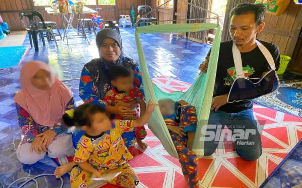 Muhammad Hafiz Rayyan (dua dari kanan) yang menghidap kanser darah memerlukan perhatian penuh daripada Ros Adnin dan Othman.