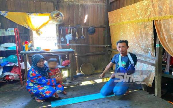 Ros Adnin dan Othman menunjukkan keadaan lantai di rumahnya yang uzur.