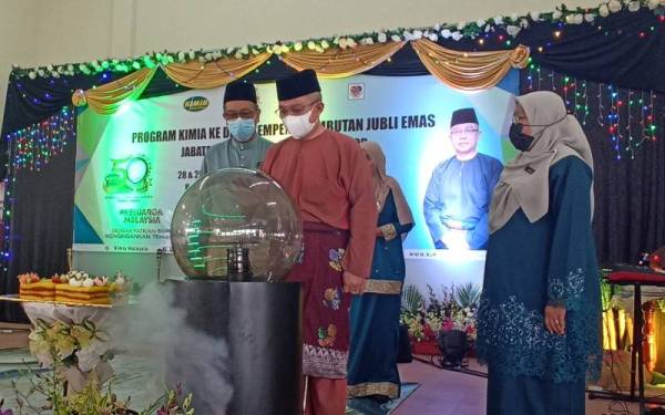 Adham (tengah) merasmikan sambutan Jubli Emas Jabatan Kimia Negeri Johor di Kampung Semangar Dalam di Kota Tinggi pada Ahad.