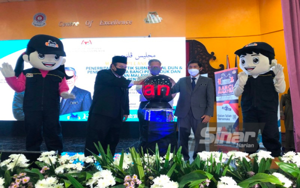 Mustapa (tengah) menyempurnakan simbolik Majlis Pelancaran Penerbitan Statistik Subnasional DUN serta Penemuan Utama Banci Penduduk dan Perumahan Malaysia 2020: Daerah Pentadbiran di Maktab Rendah Sains Mara (MRSM), di sini, pada Ahad.