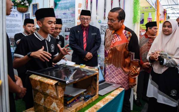 Menteri Besar Terengganu Datuk Seri Dr Ahmad Samsuri Mokhtar (tiga, kanan) meninjau projek ciptaan pelajar Sekolah Menengah Imtiaz Yayasan Terengganu Besut semasa melawat ruang pameran sempena Majlis Perasmian Sambutan Jubli Emas Yayasan Terengganu, pada Ahad. - Foto Bernama

