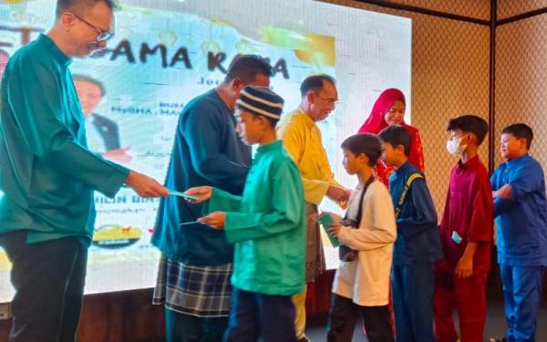 Nolee Ashilin (tiga dari kanan) menyampaikan duit raya kepada kanak-kanak yang hadir pada Rumah Terbuka Hari Raya MyBHA, MUH, MATTA dan PPPBP di Hotel Travelodge pada Ahad.