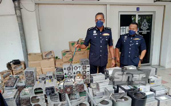 Vijaya (kiri) menunjukkan antara mesin bitcoin yang dirampas susulan tangkapan 12 individu dipercayai terlibat kes samun melibatkan sebuah kilang mesin bitcoin di Meru pada 27 April dan 20 Mei lalu.