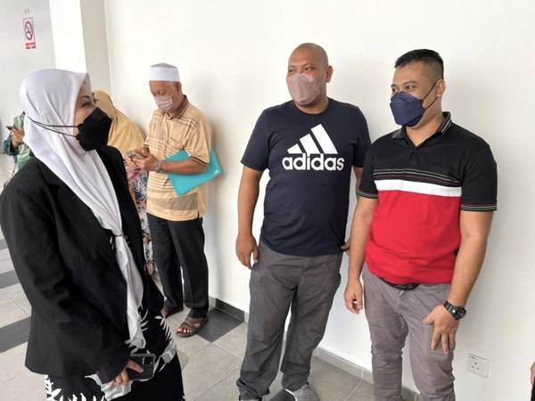 Majdah (kiri) bertemu anak guamnya, Mohd Hanafi (dua dari kanan) dan Mohammad Izauddin (kanan) di Mahkamah Sesyen Kota Bharu, pada Isnin.