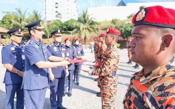 Syed Ibrahim diiringi Dr Wan Mohammad Zaidi (tiga dari kiri) menyampaikan sijil tauliah kepada Pegawai Bomba Bantuan yang menamatkan latihan sempena Majlis Perasmian Tamat Latihan dan Pentauliahan Pegawai Bomba Bantuan JBPM Pahang di Balai Bomba dan Penyelamat Indera Mahkota pada Selasa.