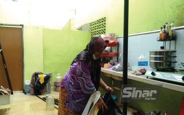 Noorazaliah membersihkan bahagian dapur rumahnya di Lorong Pengkalan Gelong, Titi Gajah, Alor Setar selepas kejadian ribut pada petang Ahad.