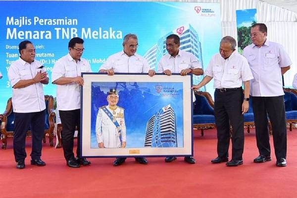 Takiyuddin (tiga dari kanan) menyampaikan cenderahati sempena Majlis Perasmian Menara TNB Melaka kepada Tun Mohd Ali Mohd Rustam (tiga dari kiri) pada Selasa