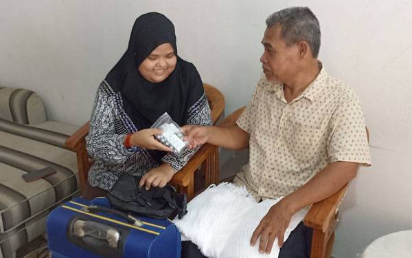 Nurul Afiqah memberikan ubat kencing manis kepada Abu Bakar.
