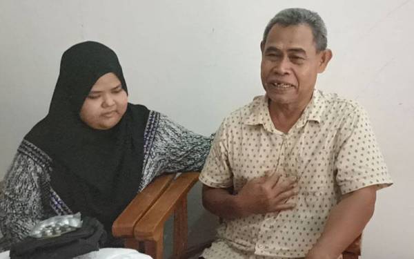 Abu Bakar ditenangkan anak bongsunya, Nurul Afiqah ( kiri) apabila tidak dapat menahan sebak kerana dirinya terpilih ke Tanah Suci tahun ini.