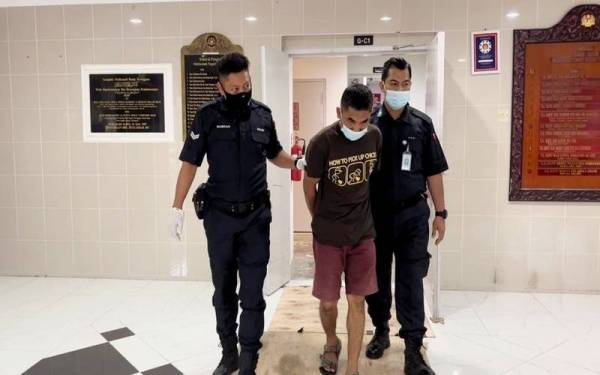 Tertuduh (tengah) ketika dihadapkan ke Mahkamah Majistret pada Rabu.