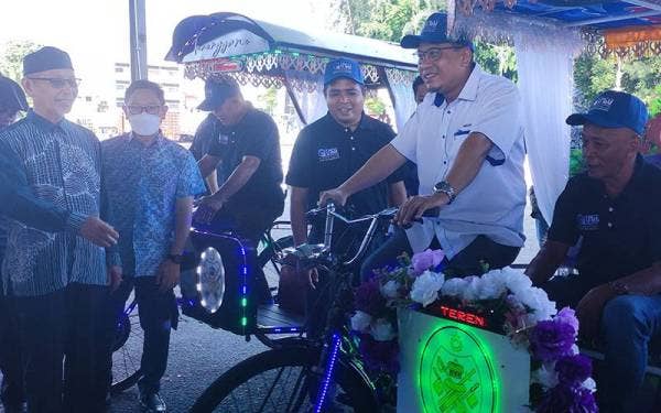 Ahmad Amzad (dua dari kanan) mencuba e-Beca yang menggunakan teknologi boleh dicas melalui tenaga solar selepas melancarkan inovasi baharu itu pada Khamis.