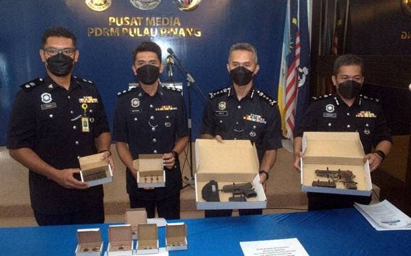 Mohd Shuhaily (dua dari kanan) menunjukkan senjata api yang dirampas daripada kumpulan penjenayah terbabit pada 24 Mei lalu.