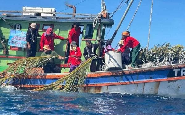 Dr Azman (dua dari kanan) turut serta melabuhkan sebanyak 40 unjam di Pulau Redang bagi memperkayakan hasil laut.