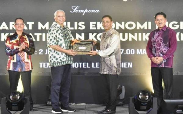 Annuar menerima cenderahati daripada Yakub pada Majlis Makan Malam sempena mesyuarat Majlis Ekonomi Digital, Industri Kreatif dan Komunikasi (MEDIKK), di Kota Kinabalu.