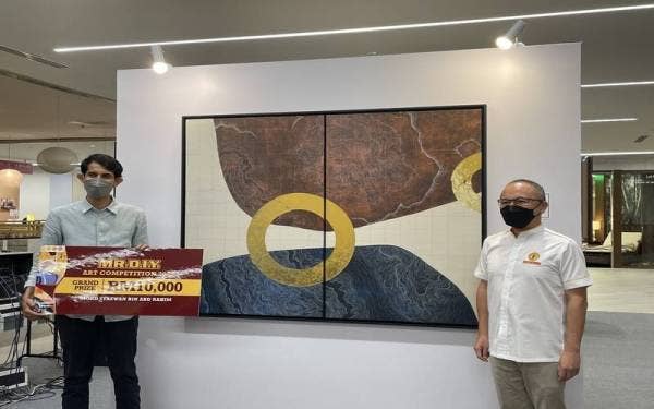 Mohd Syazwan (kiri) menerusi hasil karya seninya bertajuk ‘Upside Down’ bersama Adrian Ong (kanan) memenangi hadiah utama pertandingan seni Kumpulan MR D.I.Y. yang membawa pulang wang tunai RM10,000.