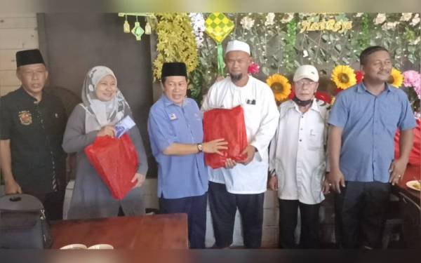 Ahmad (tiga dari kiri) menyampaikan sumbanban kepada bakal jemaah haji di sebuah restoran di bandar Pontian pada Jumaat.