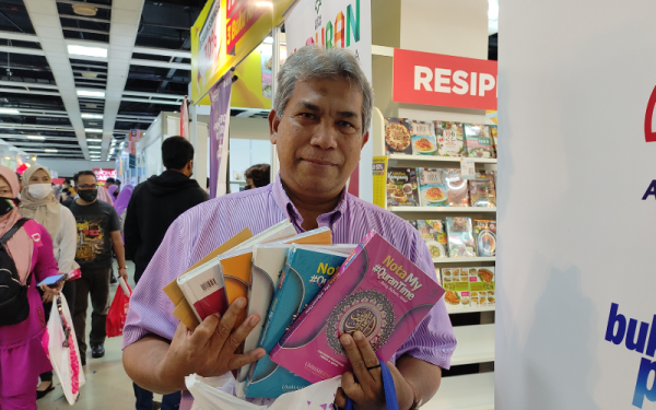 Wan Kozil menunjukkan buku yang dibeli di reruai Karangkraf di PBAKL yang diadakan di WTCKL pada Sabtu.