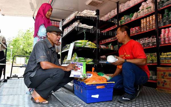 Timbalan Menteri Perdagangan Dalam Negeri dan Hal Ehwal Pengguna Datuk Rosol Wahid (kiri) meninjau tepung gandum yang dijual semasa Program Jualan Kedai Prihatin di Kampung Gaung, Hulu Terengganu hari ini.