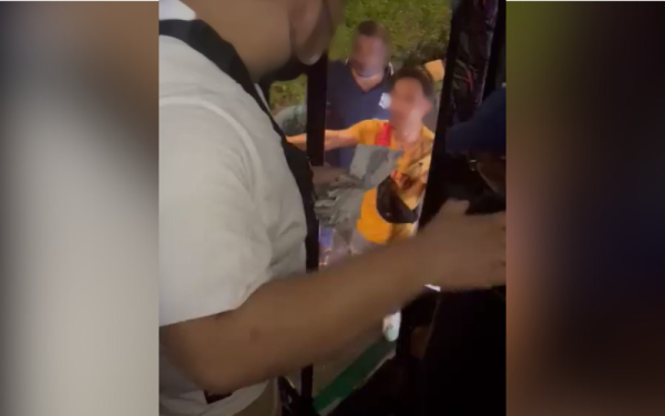 Tangkap layar video tular menunjukkan rakaman pertelingkahan antara empat individu dengan seorang penumpang bas.