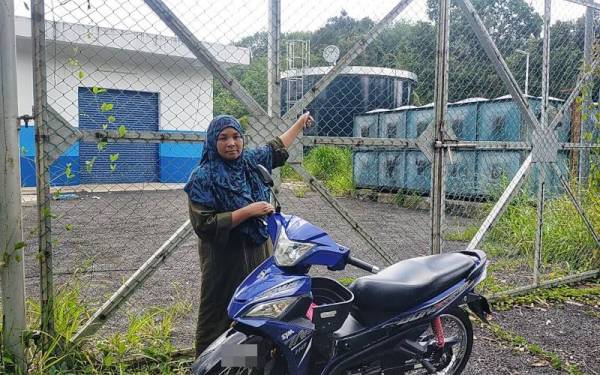 Nor Hayati menunjukkan tangki air SADA yang siap dibina baru-baru ini di Kampung Wang Perah, Jitra.