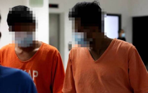 Suspek (kanan) ketika dibawa ke Mahkamah Kota Bharu bagi mendapatkan perintah tahanan reman sebelum ini. - Foto fail