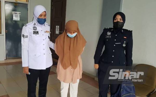 Tertuduh (tengah) diiring polis di Mahkamah Majistret Seremban pada Selasa.