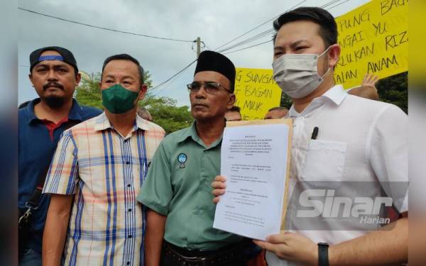Teck Huat (kanan) menunjukkan memorandum yang diserahkan kepada PDT Kuala Selangor pada Selasa.