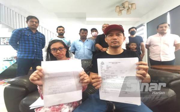 Abdul Halim dan Nor Sabrina menunjukkan laporan polis yang dibuat. Turut menyokong tindakannya empat NGO (berdiri belakang).