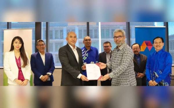 Ahmad Rizal (tiga dari kiri) dan Afizulazha (tiga dari kanan) bertukar dokumen perjanjian dan disaksikan oleh Salleh serta wakil QSB dan Celcom yang hadir pada majlis MoU itu.
