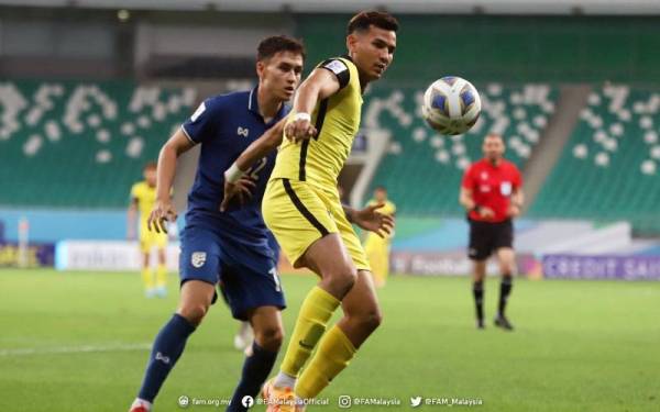 Penyerang negara, Hadi Fayyadh Abdul Razak dicabar pemain Thailand dalam aksi di Stadium Bunyodkor, Tashkent pada Ahad.